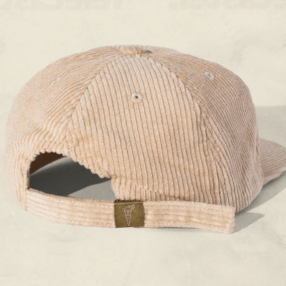 Tan corduroy cap on a light beige background, back view