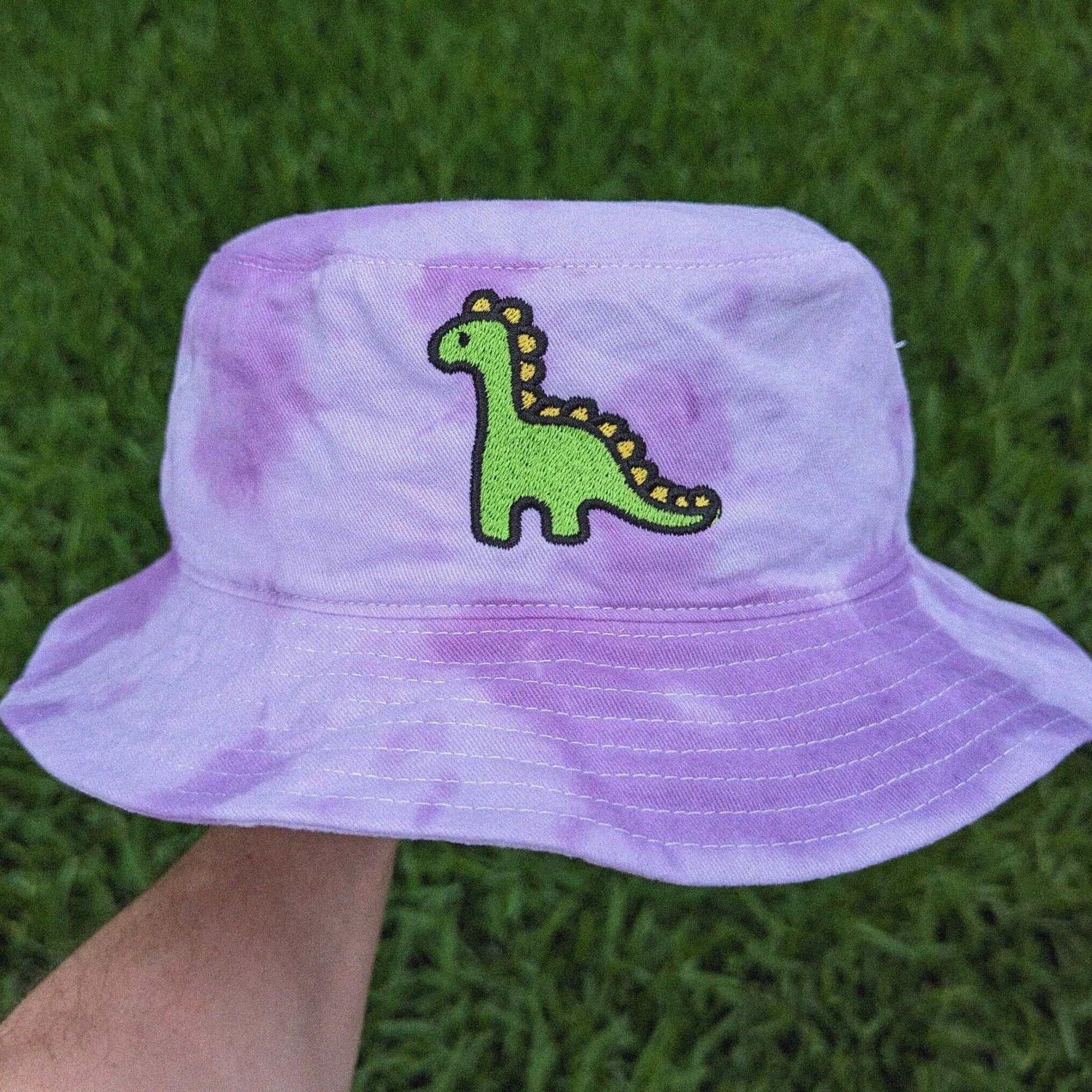 Purple tie-dye bucket hat with a green dinosaur design