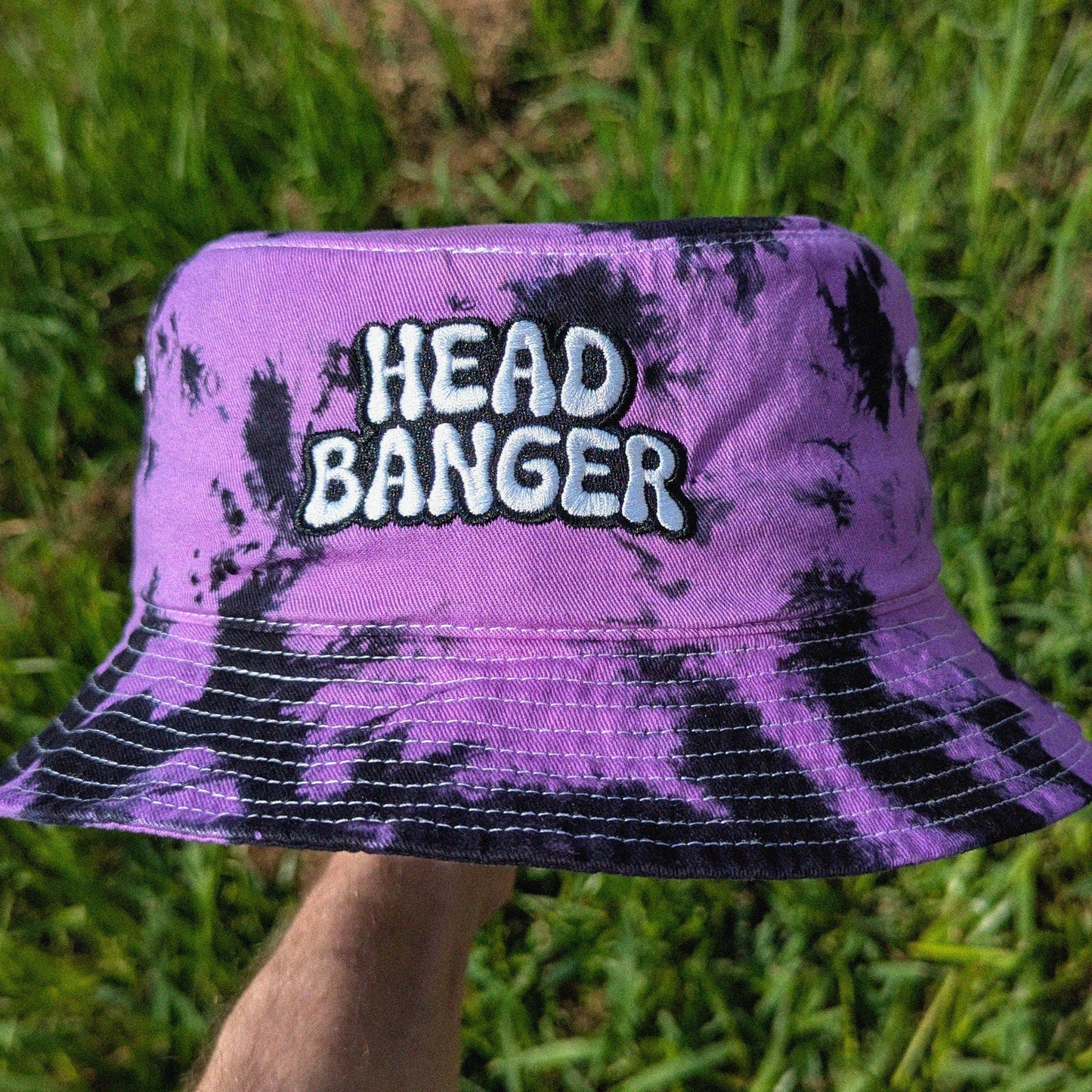 Purple tie-dye bucket hat with 'HEAD BANGER' text
