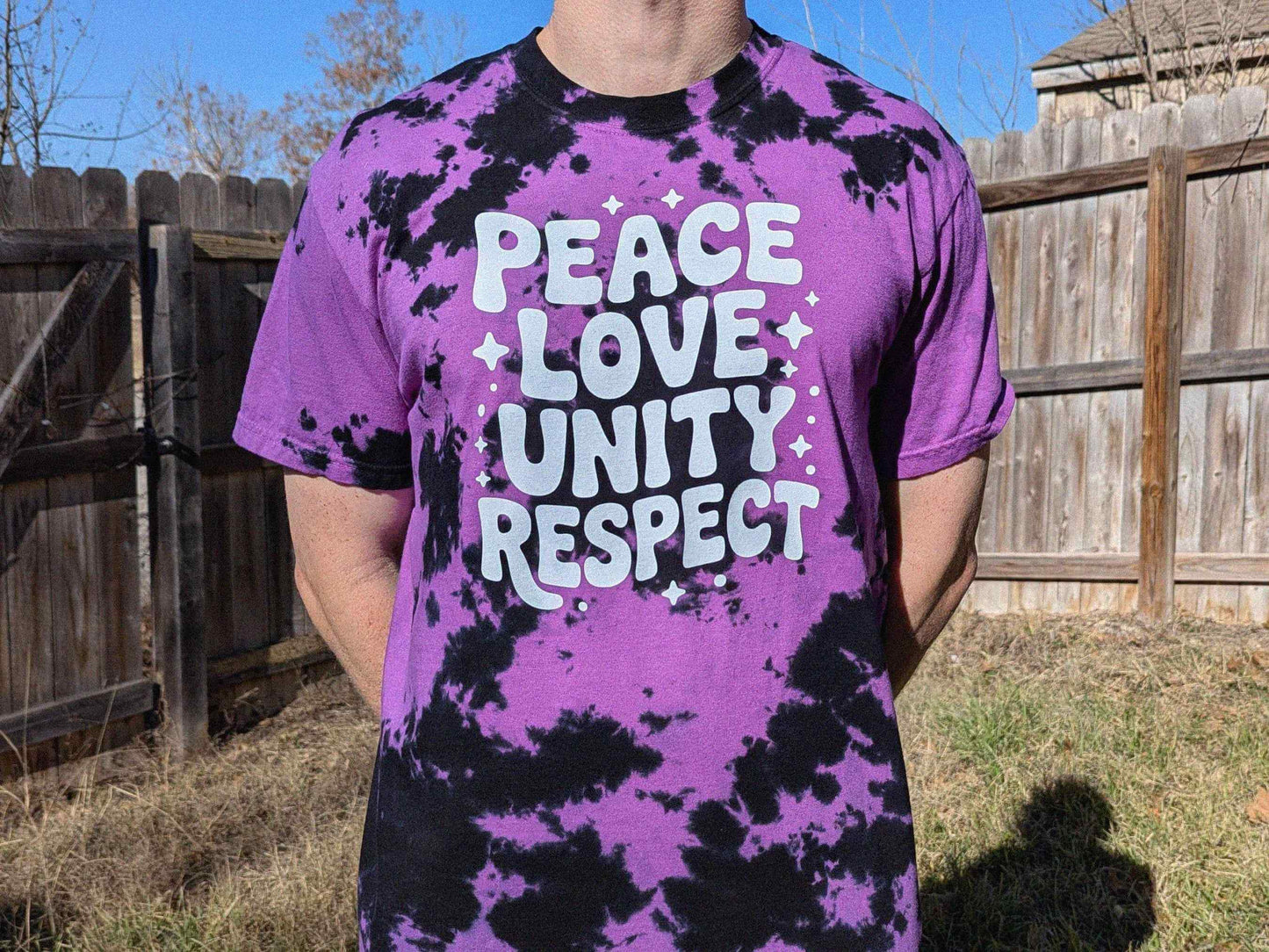 Purple and black tie dye PLUR rave shirt with ‘Peace Love Unity Respect’ text, EDM festival outfit for raves and music festivals