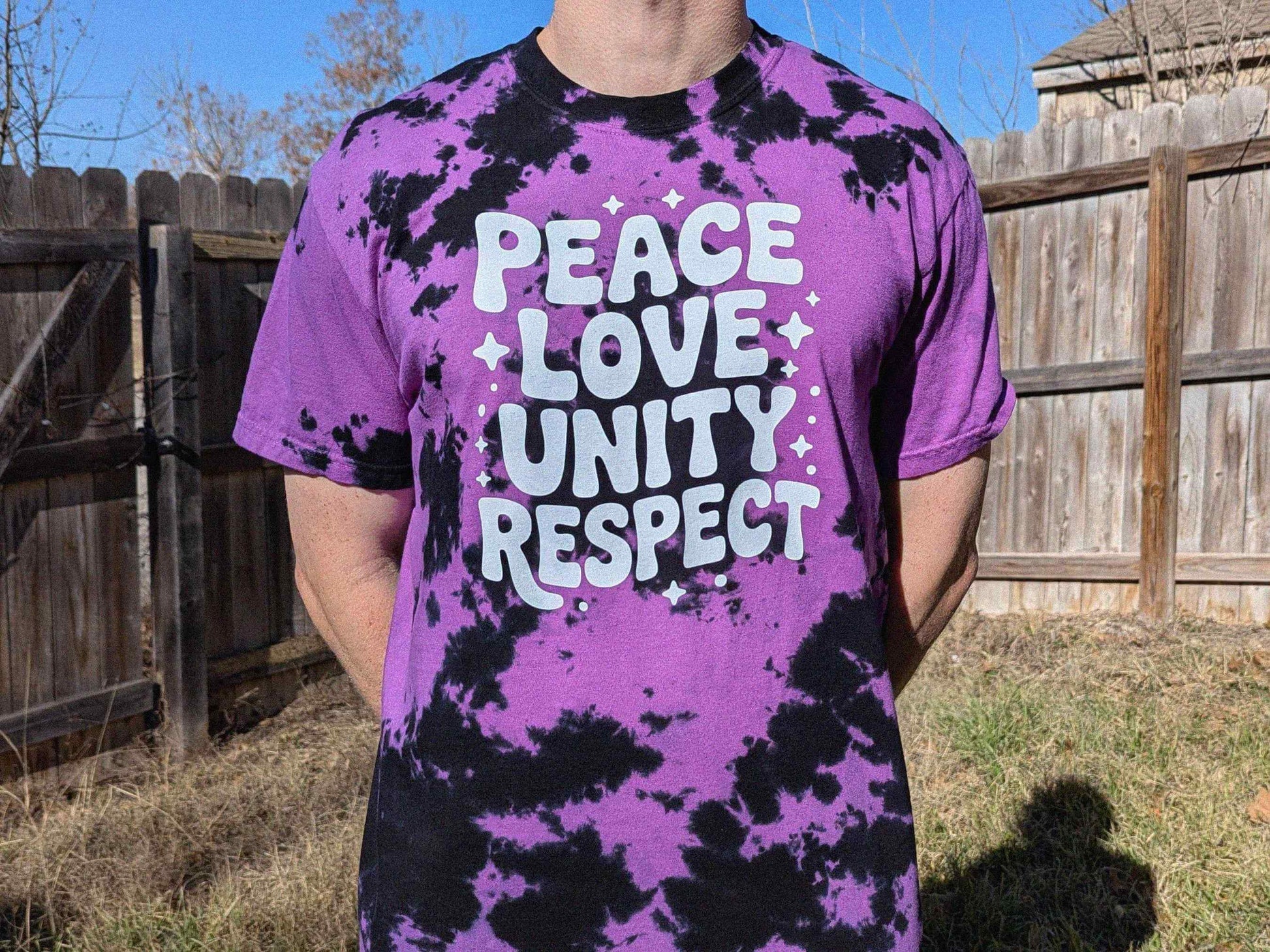 Purple and black tie dye PLUR rave shirt with ‘Peace Love Unity Respect’ text, EDM festival outfit for raves and music festivals