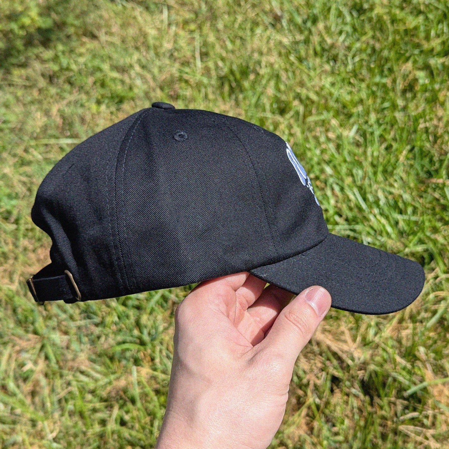 side view of rave cap that has 'Riddim Rat' embroidered on the front