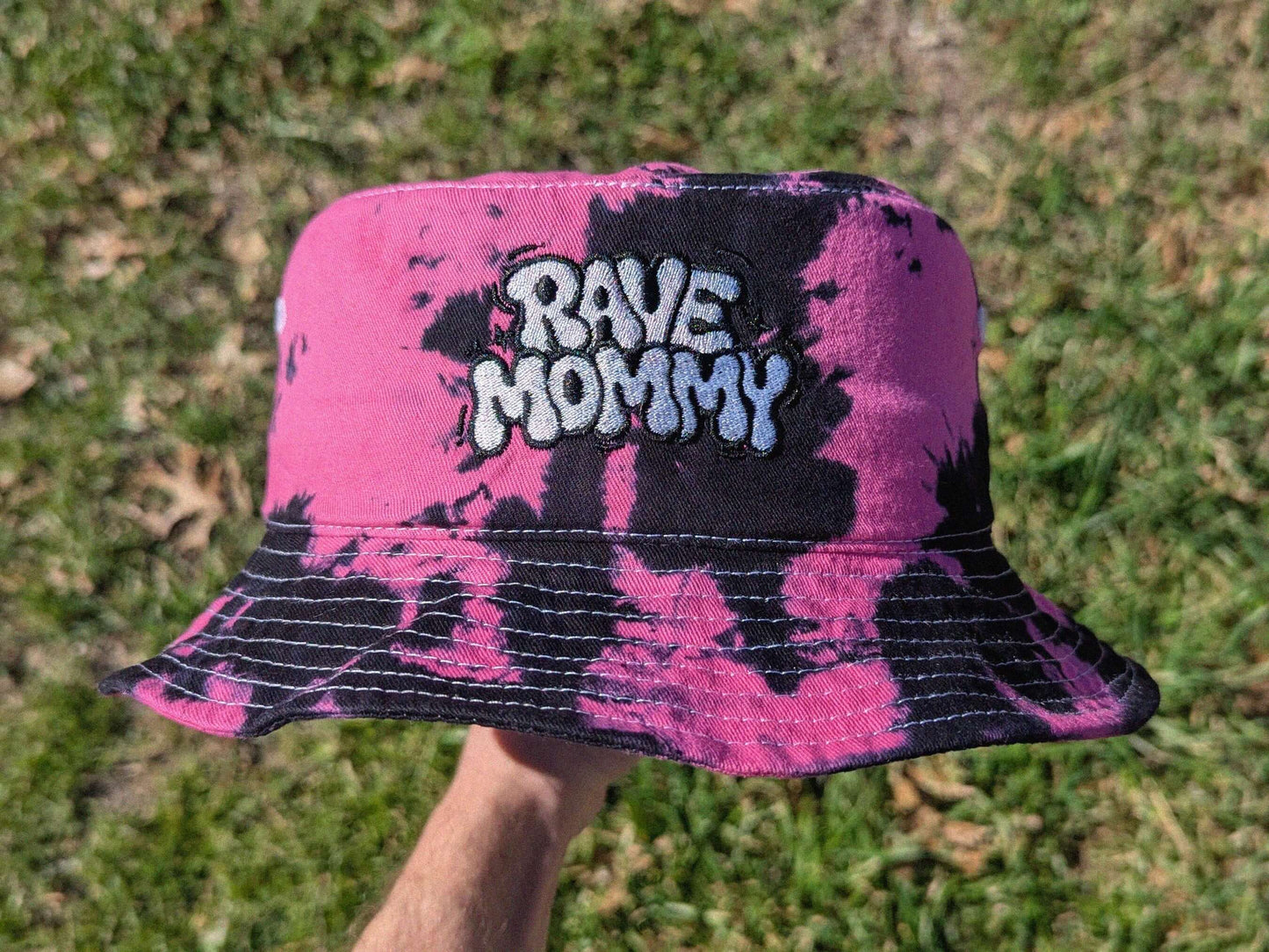 Pink and black tie dyed bucket hat with 'RAVE MOMMY' text