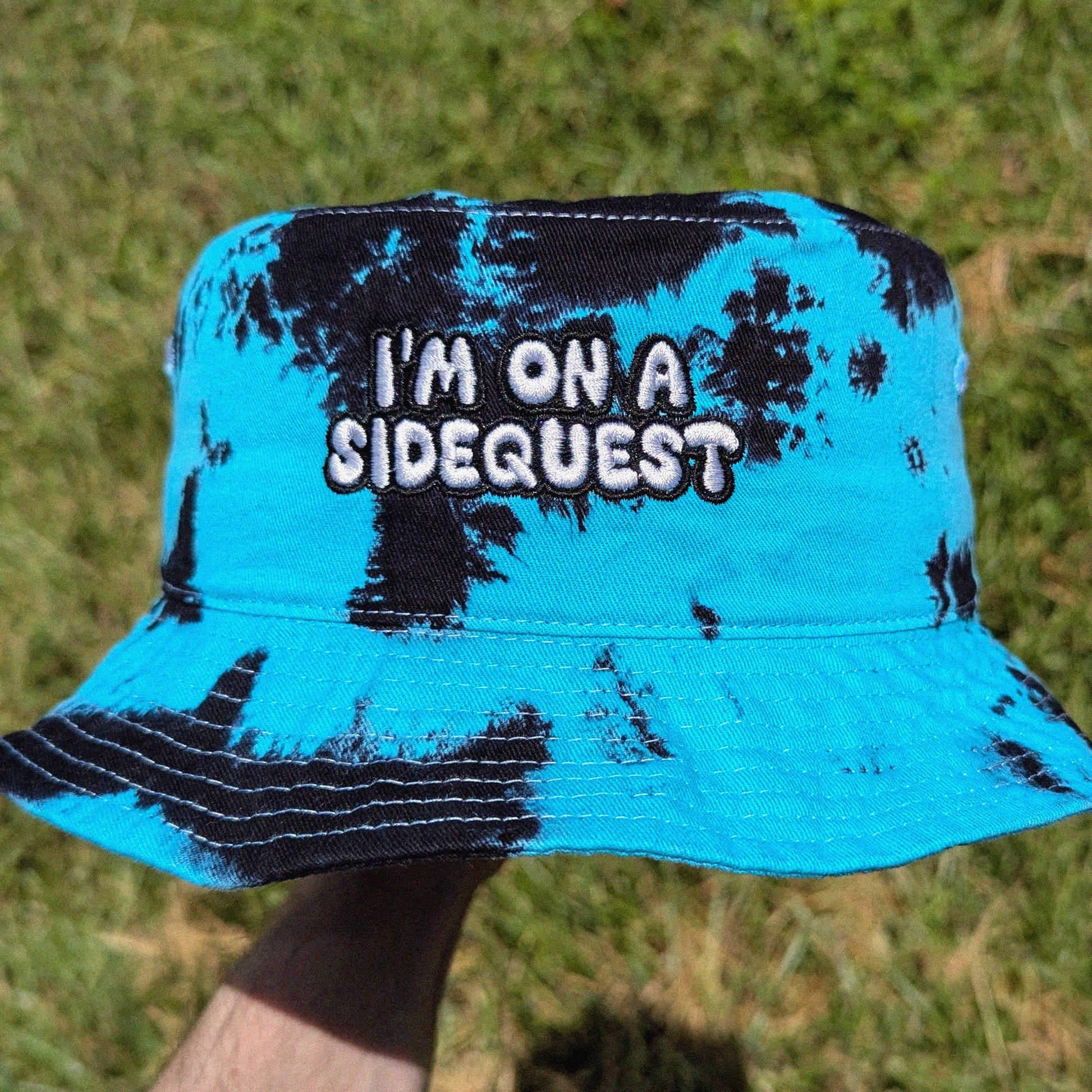 tie dye rave bucket hat with 'i'm on a sidequest' embroidery