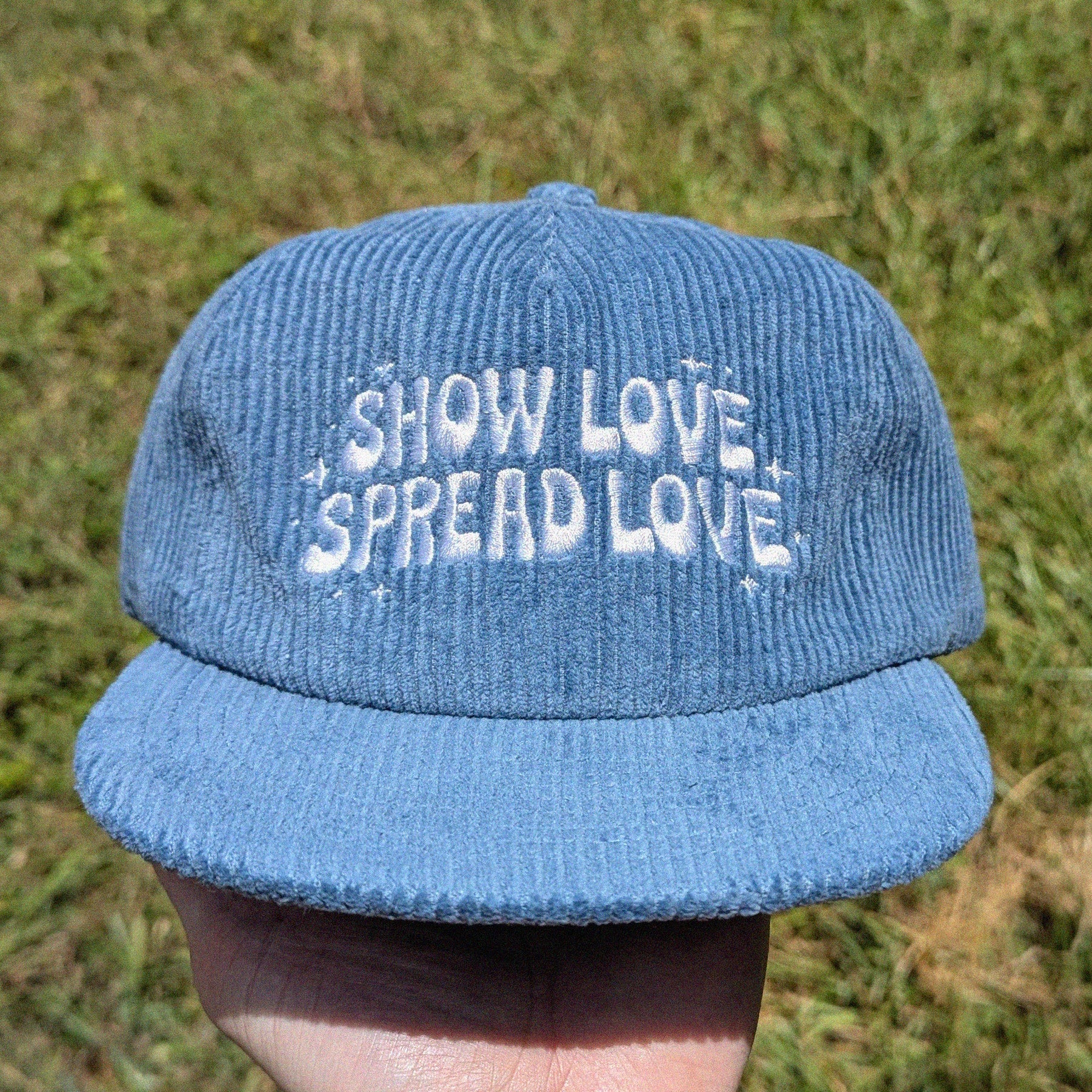 blue corduroy cap with 'Show Love Spread Love' embroidery