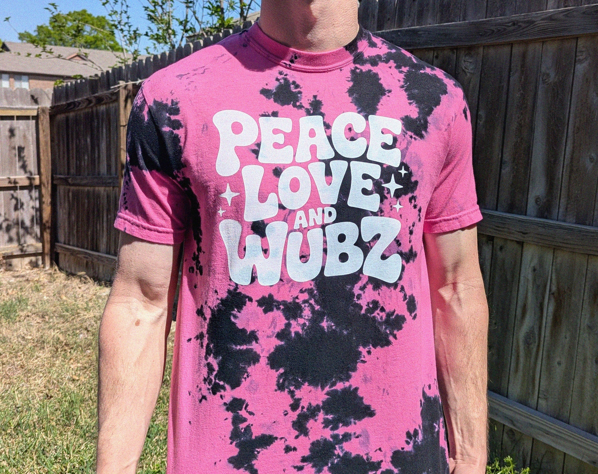 Person wearing a pink and black tie-dye t-shirt with 'Peace Love and WUBZ' text.
